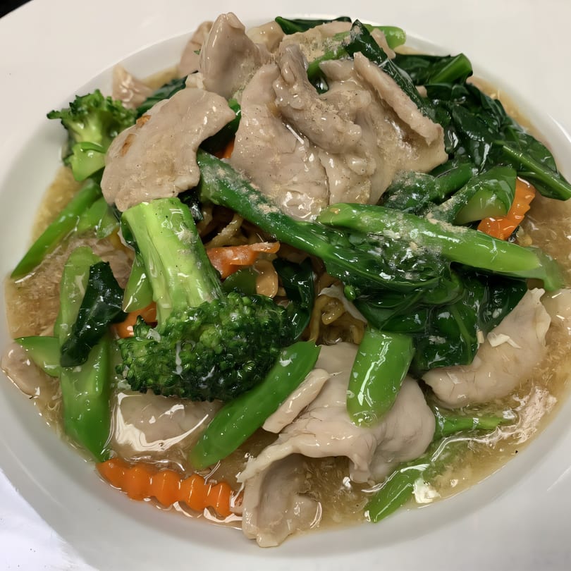 Thai Rad Na with wide rice noodles, pork, broccoli, carrots, and Chinese broccoli in gravy.