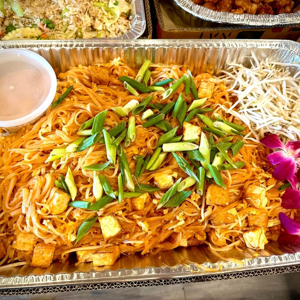 Thai2You's Pad Thai with tofu, bean sprouts, green onions, and a purple orchid garnish.